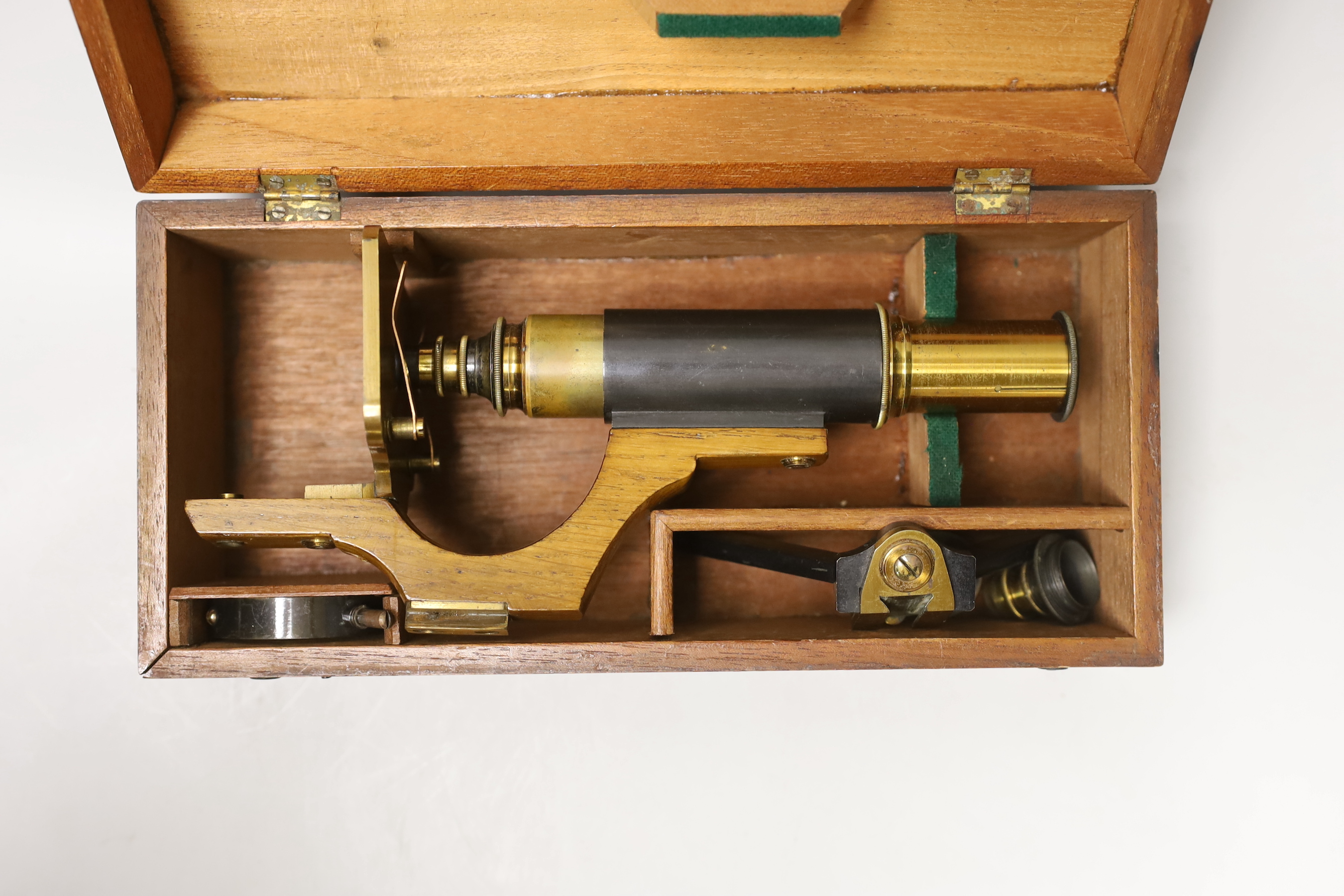 A lacquered brass field microscope, in fitted case, case 26cm wide